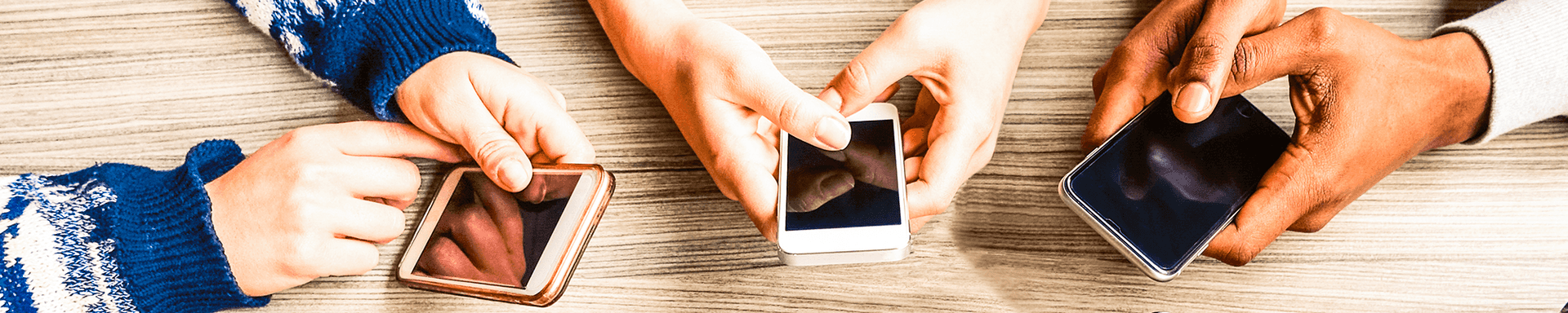multiple phones connected with netspeed being held by people at a table